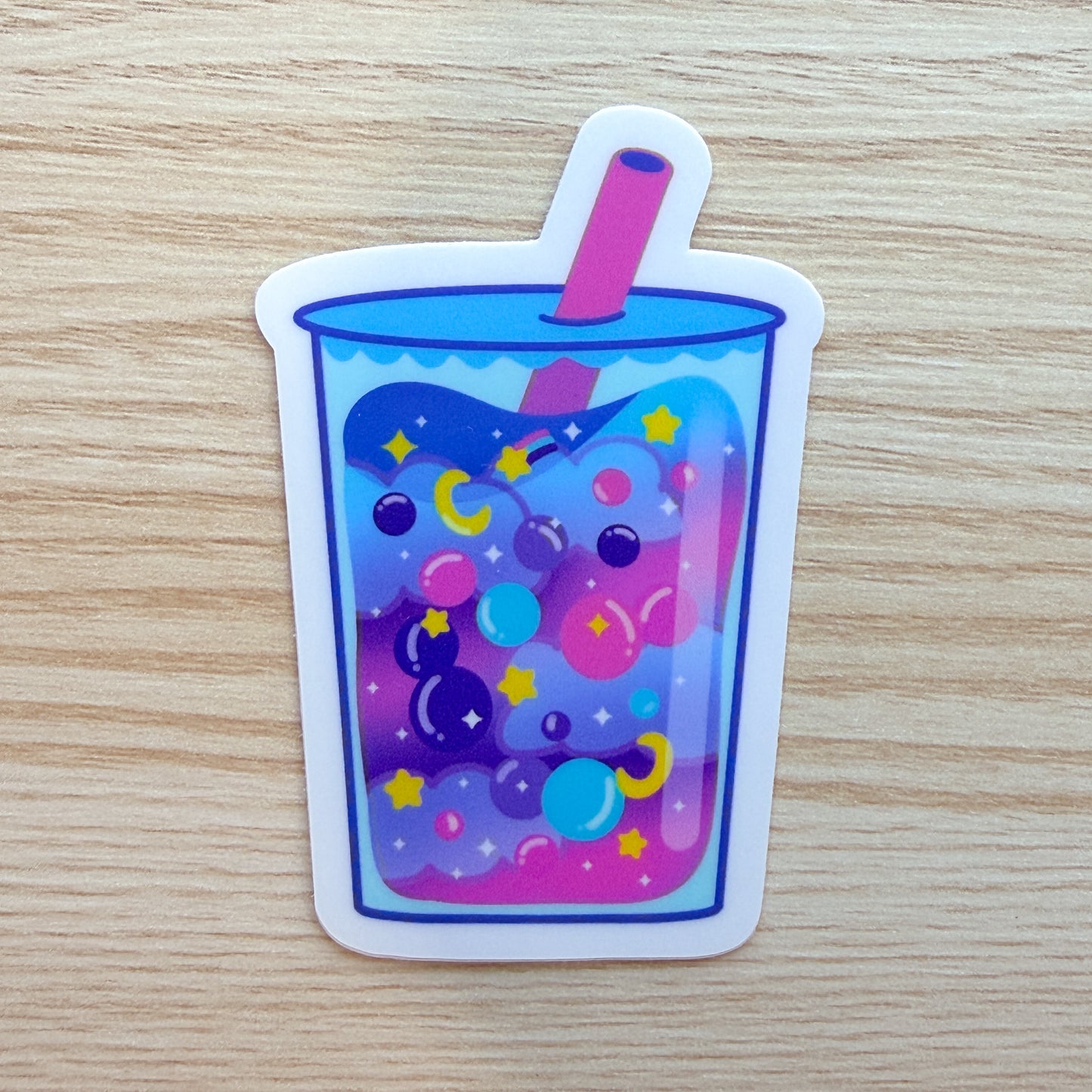 Colorful drink with bubbles and a straw on a wooden surface
