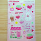 Sticker sheet with cute illustrations and text on a pink background, featuring the brand 'happy olive studios'.