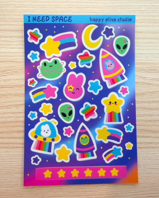 Colorful sticker sheet with various space themed designs on a wooden surface