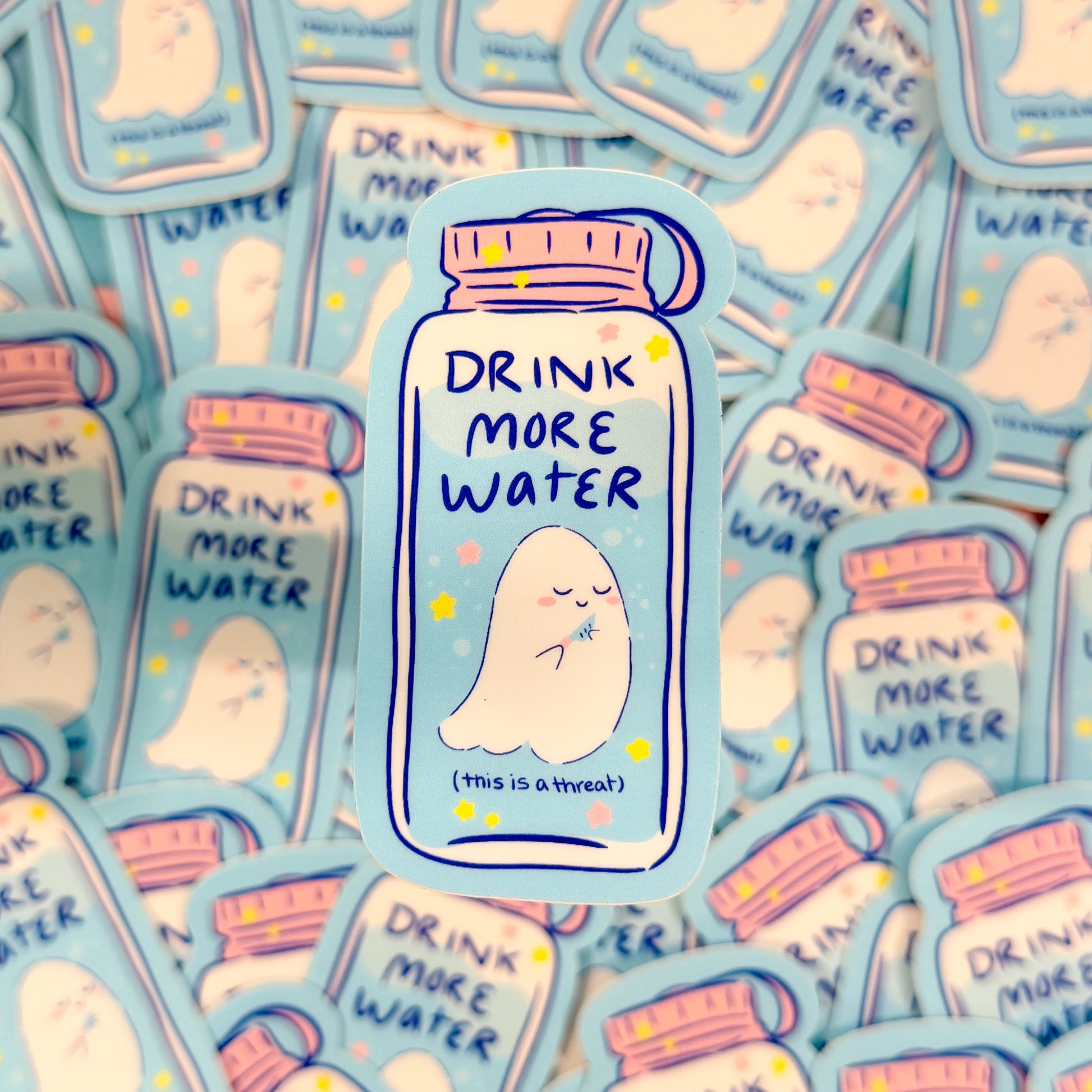 Sticker with 'Drink More Water' text on a blue background, surrounded by similar stickers.